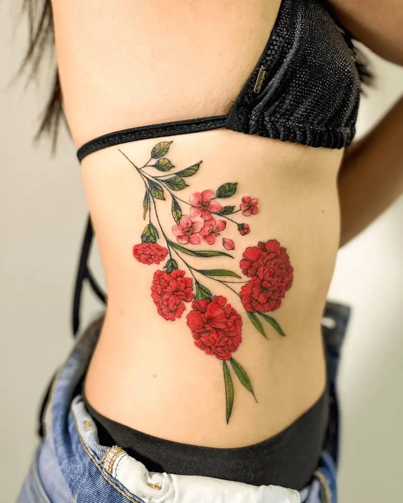 Floral Color Tattoo of Red Carnations and Cherry Blossoms Over Ribs